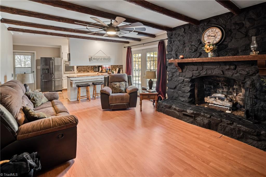 2198 South McKinney Road Mount Airy, NC 27030 - Photo 17 of 48 The living room is open to the Kitchen and features a large rock fireplace with gas logs, and the beams give the rustic vibe.