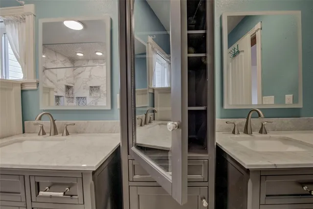 a bathroom with a granite countertop sink and a mirror