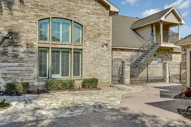 a view of a brick house with large windows and a large tree
