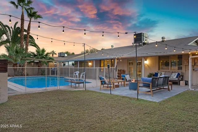 a view of a house with a swimming pool and sitting area