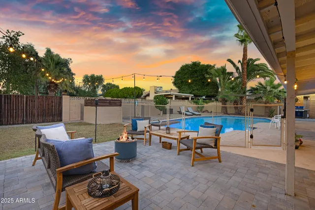 a view of a swimming pool with a patio and a fire pit