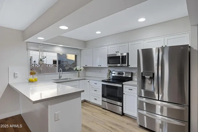 a kitchen with stainless steel appliances a refrigerator sink and microwave
