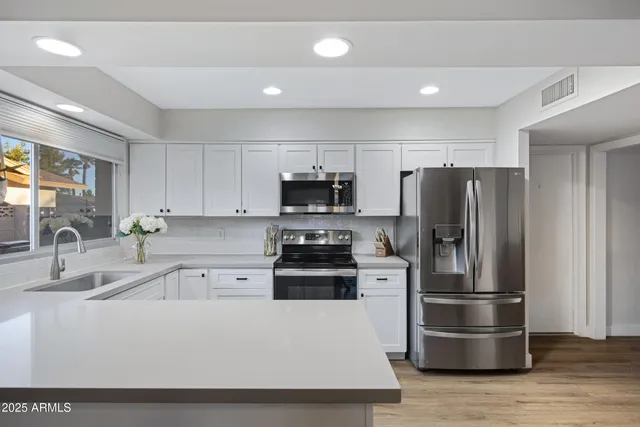 a kitchen with stainless steel appliances a refrigerator a stove a sink and a granite counter tops