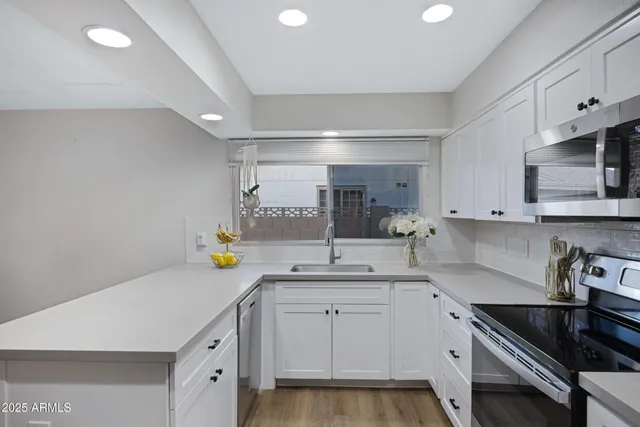 a kitchen with a sink cabinets and stainless steel appliances