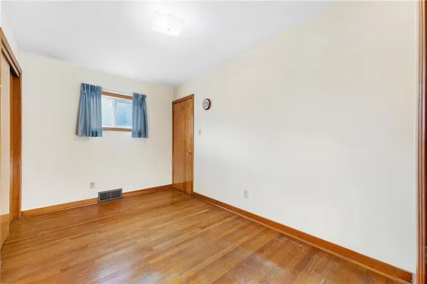 an empty room with wooden floor and closet