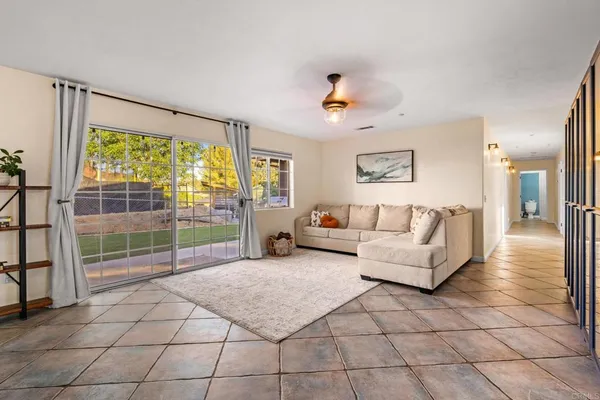 a living room with furniture and a floor to ceiling window