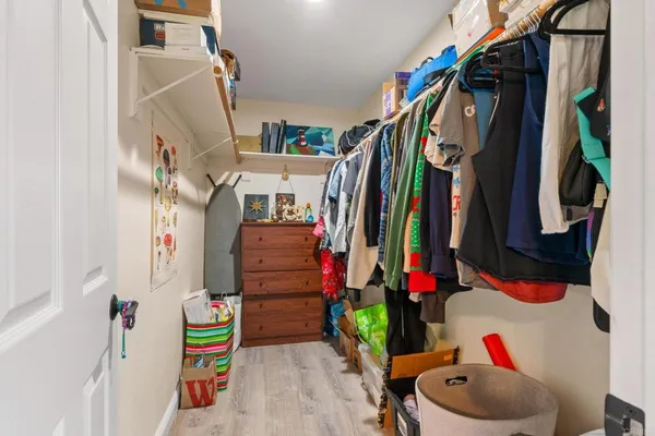 a view of walk in closet with clothes and shoes