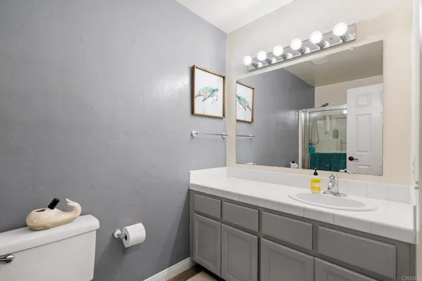 a bathroom with a sink vanity mirror and toilet
