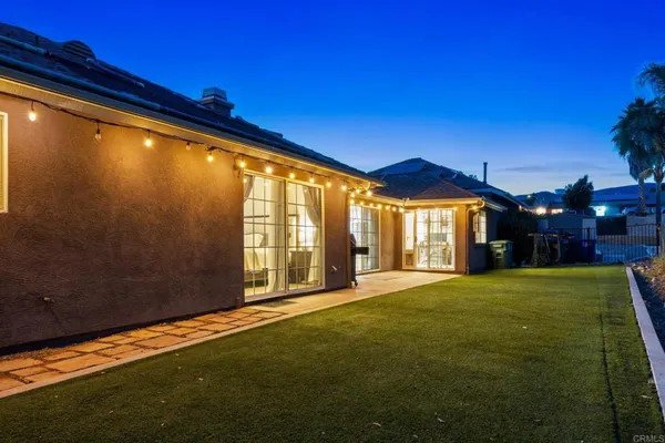a view of an house with backyard space and balcony