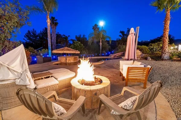 a view of a patio with a dining table and chairs with fire pit