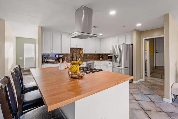 a kitchen with a refrigerator a stove top oven a sink dishwasher and white cabinets with wooden floor