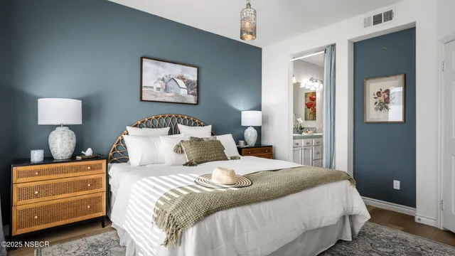 a bedroom with a bed and a lamp on dresser