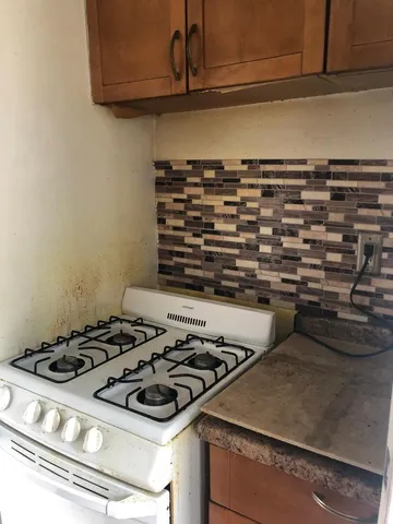 a stove top oven sitting inside of a kitchen