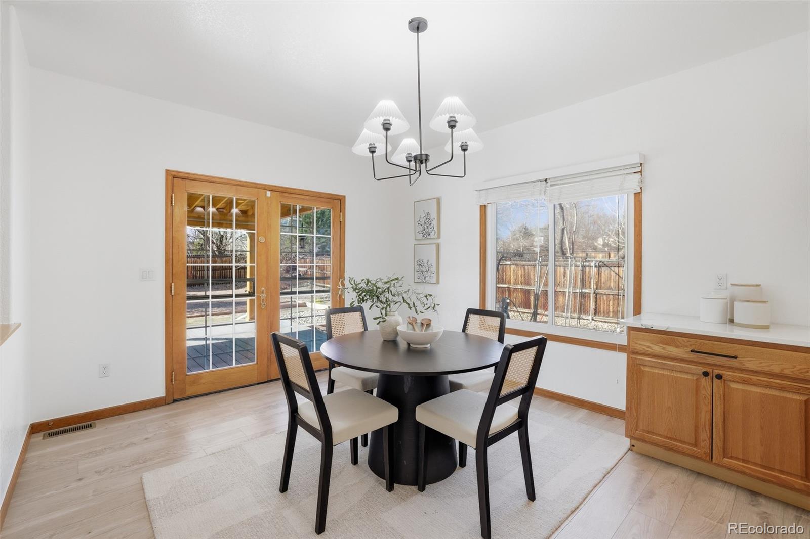 10917 Ammons Street Broomfield, CO 80021 - Photo 12 of 47 a dining room with wooden floor a chandelier a wooden table and chairs