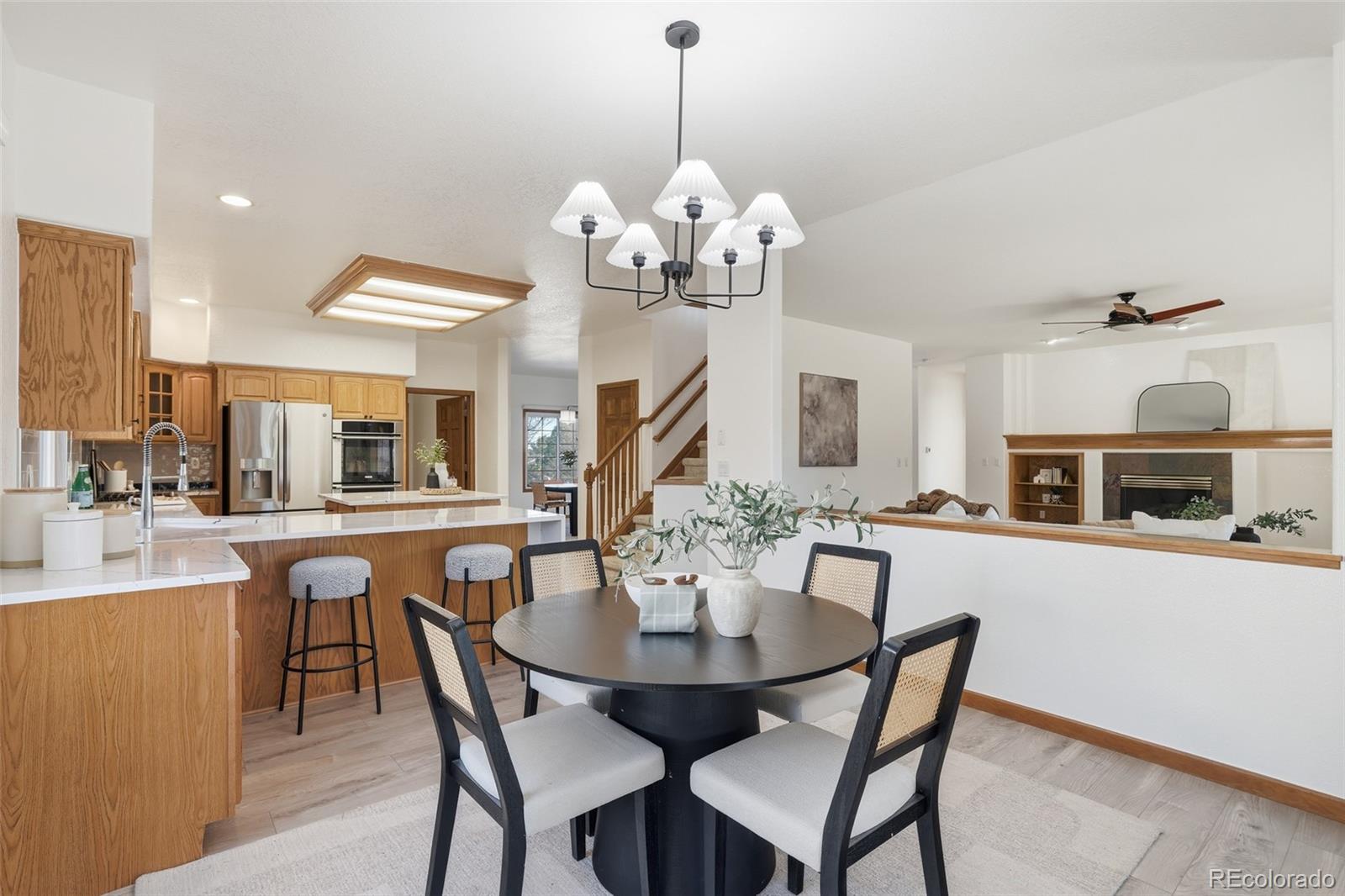 10917 Ammons Street Broomfield, CO 80021 - Photo 13 of 47 a dining room with wooden floor a chandelier a wooden table and chairs