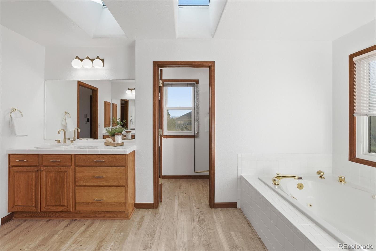 10917 Ammons Street Broomfield, CO 80021 - Photo 25 of 47 a bathroom with a tub sink and mirror