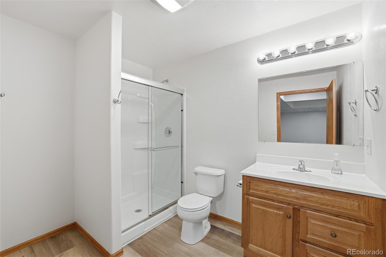 10917 Ammons Street Broomfield, CO 80021 - Photo 38 of 47 a bathroom with a toilet a sink a vanity and mirror