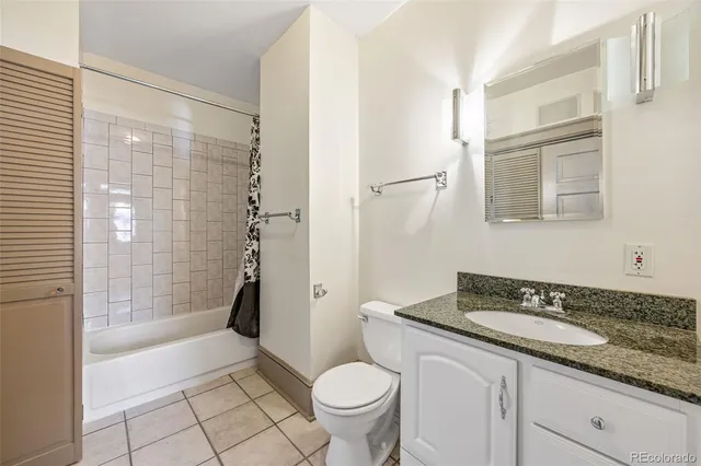 a bathroom with a granite countertop sink a toilet and shower