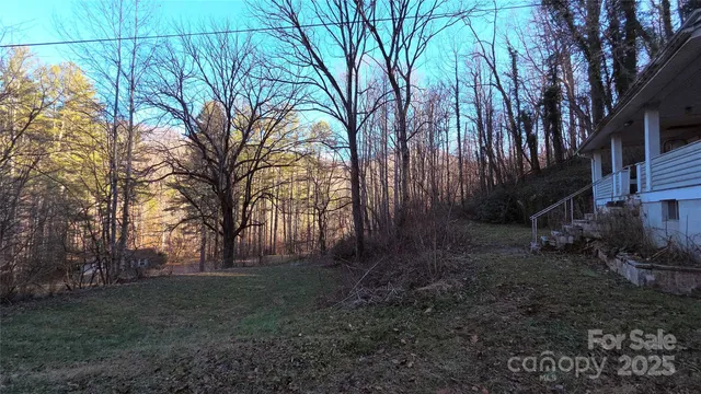 a view of backyard with table and chairs under an umbrella