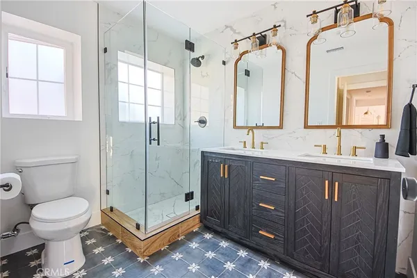 a bathroom with a double vanity sink toilet and shower