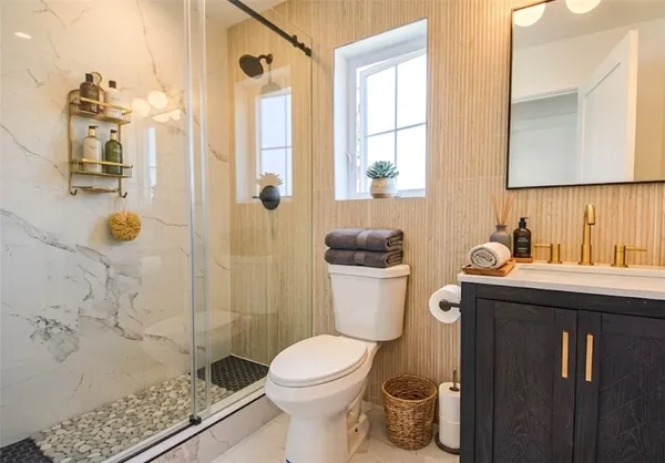 a bathroom with a granite countertop sink toilet and shower