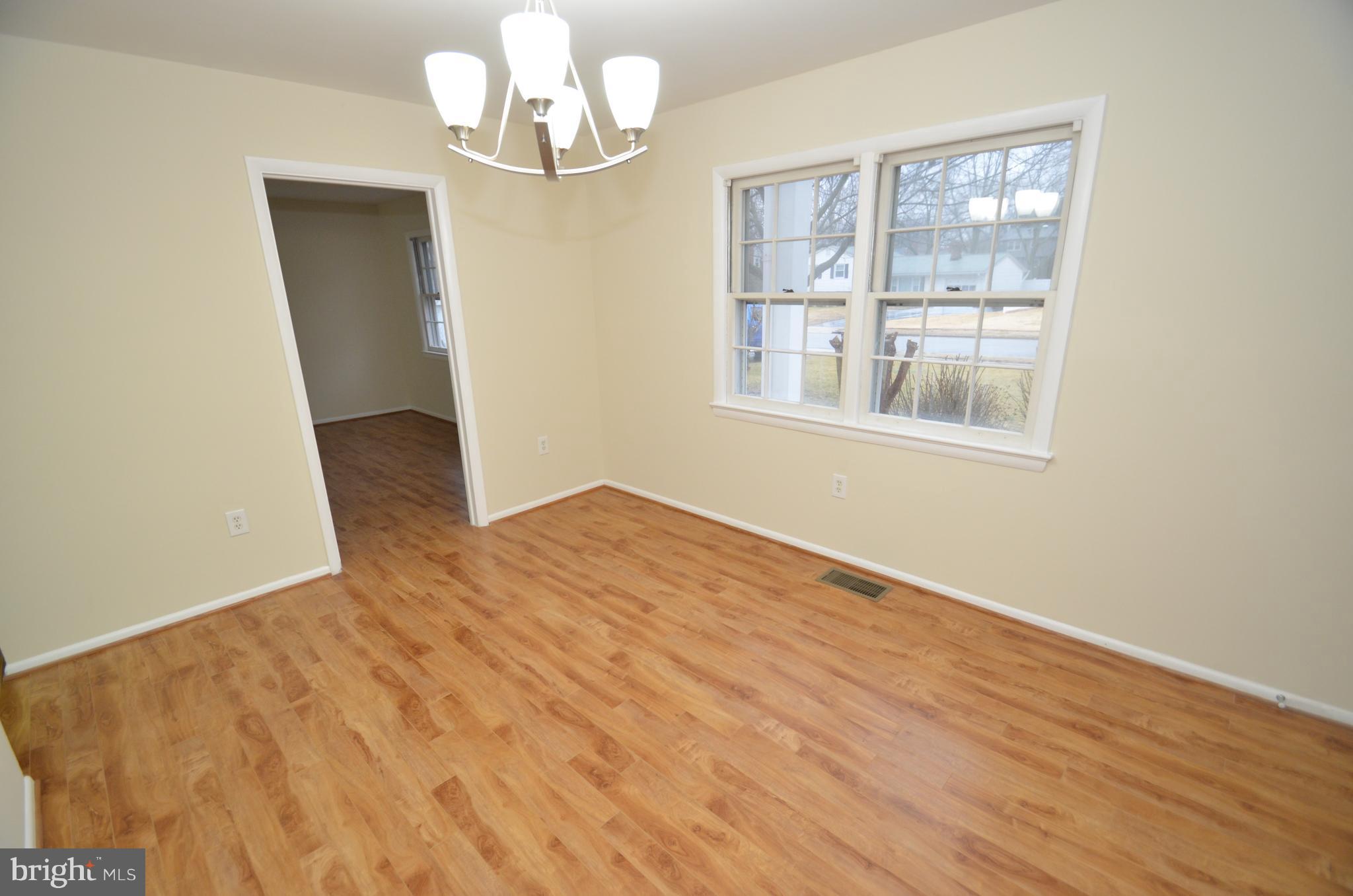 5612 Ashfield Road Alexandria, VA 22315 - Photo 11 of 29 an empty room with wooden floor cabinet and windows