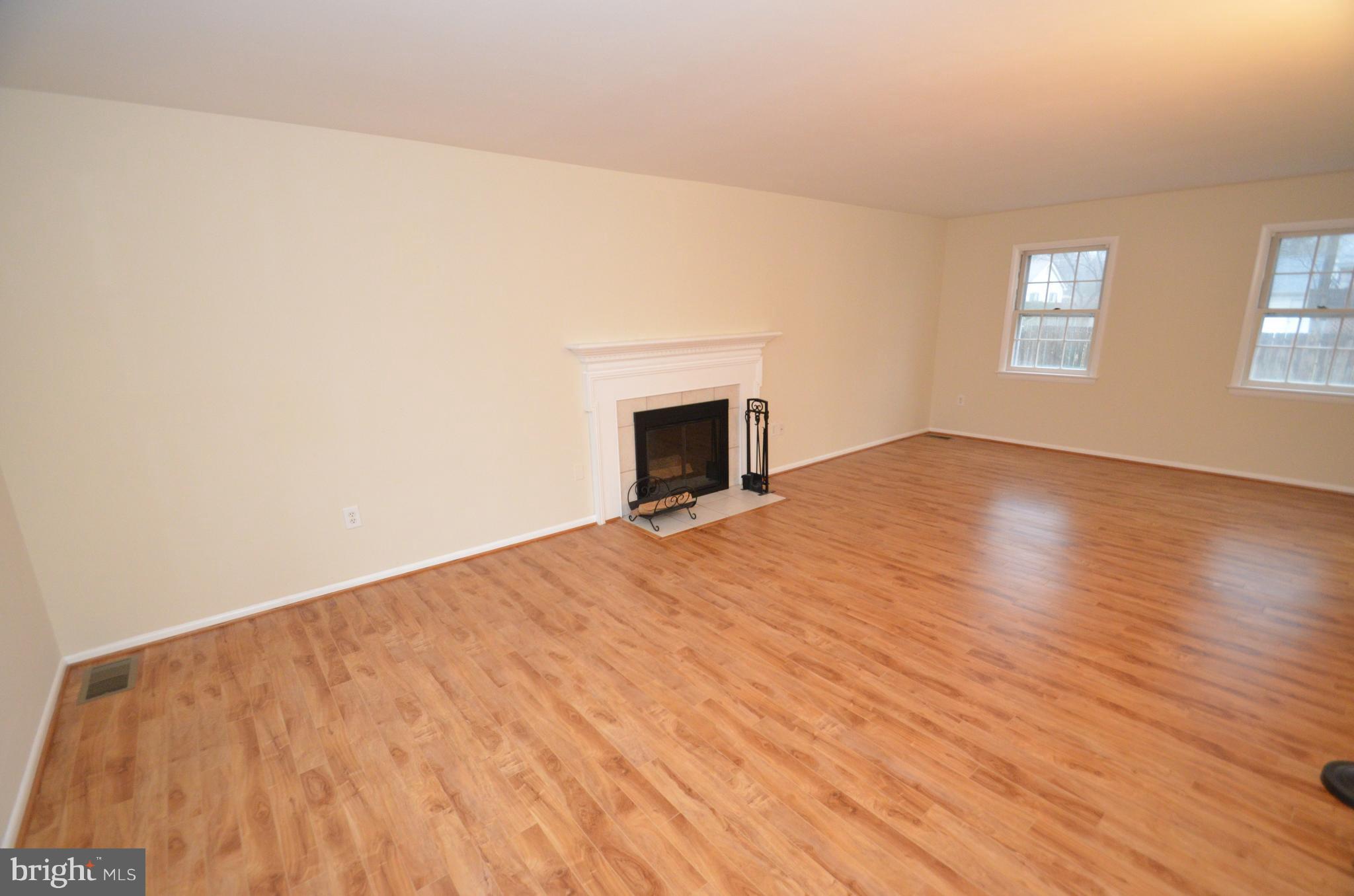 5612 Ashfield Road Alexandria, VA 22315 - Photo 4 of 29 a view of empty room with wooden floor and fireplace