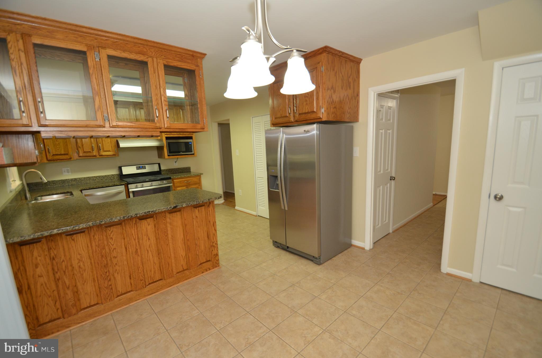 5612 Ashfield Road Alexandria, VA 22315 - Photo 7 of 29 a kitchen with stainless steel appliances granite countertop a refrigerator and a stove top oven