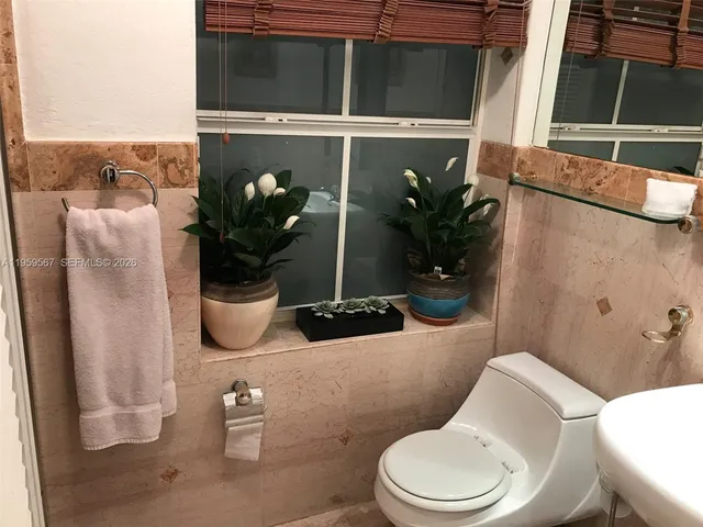 a bathroom with a toilet a sink and mirror