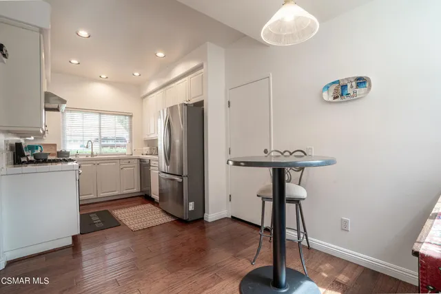a kitchen with stainless steel appliances a refrigerator and a stove top oven