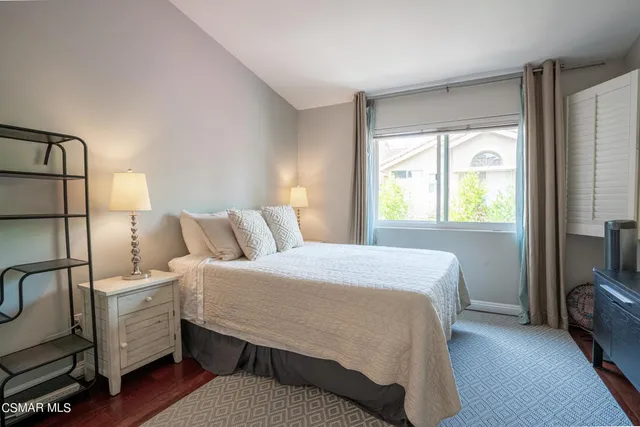 a bedroom with a bed and a tv on the dresser