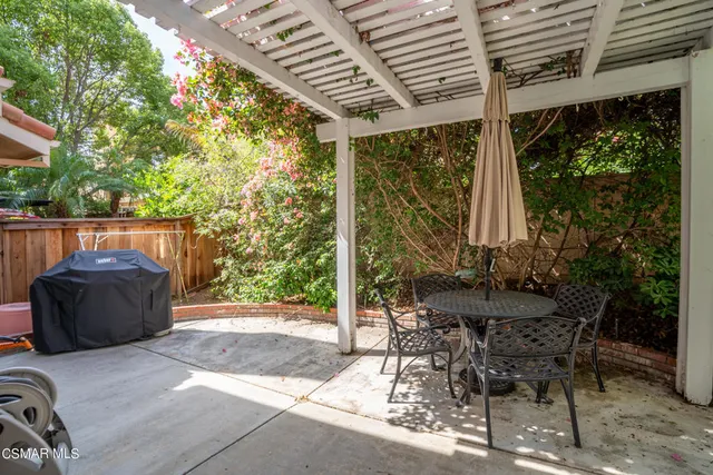 a view of a patio with table and chairs with wooden floor and fence and plants