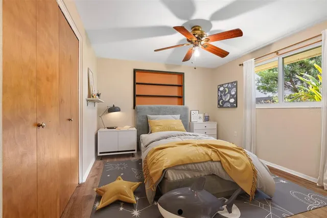 a bed room with a bed and a ceiling fan