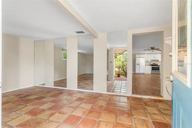 a view of a hallway to a livingroom with wooden floor and a cabinet