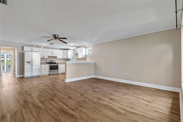 a view of a kitchen with a sink stove cabinets and empty room