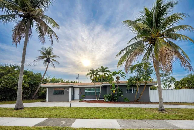 a front view of multi story residential apartment building with yard and green space