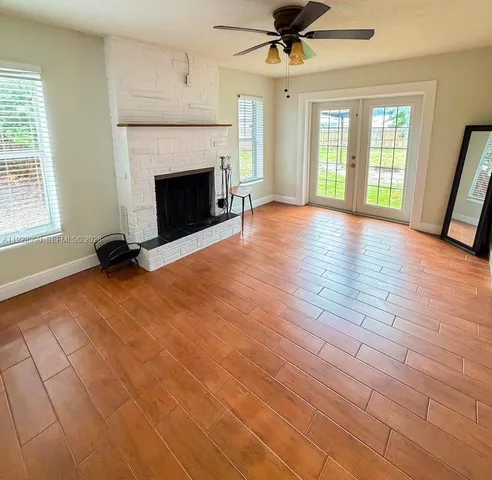 a view of an empty room with window and fire place
