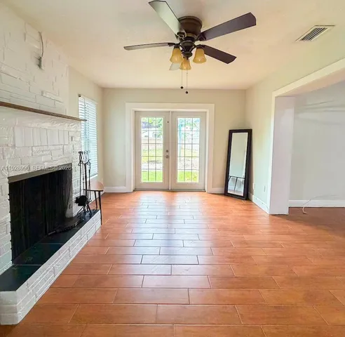 a view of an empty room with a fireplace and a window