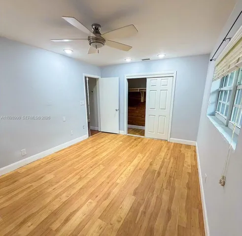 a big room with wooden floor and a ceiling fan