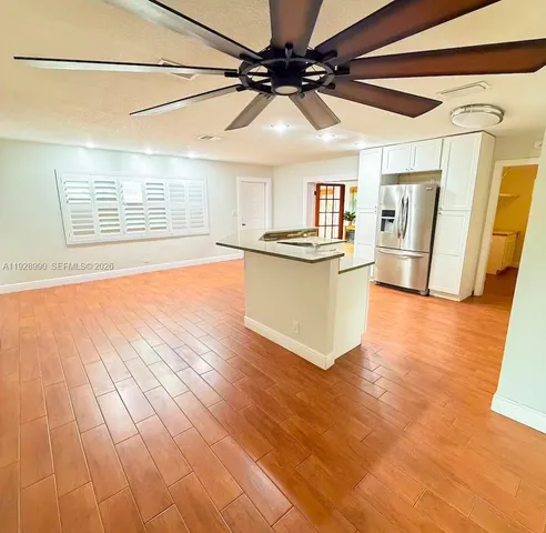 a view of a kitchen with a sink and wooden floor