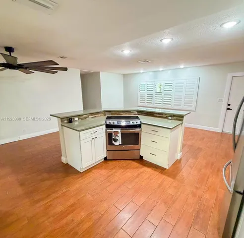 a kitchen with stainless steel appliances granite countertop a stove a sink and a microwave