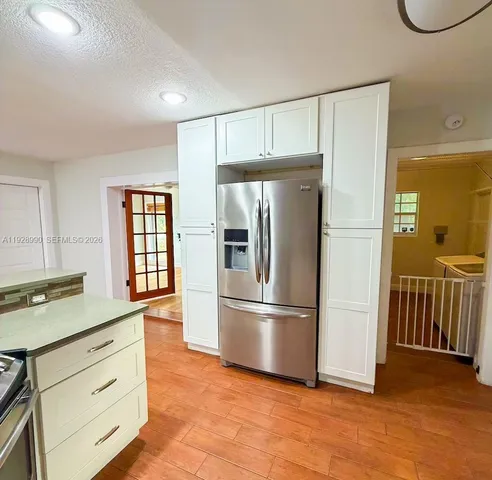 a kitchen with granite countertop white cabinets and stainless steel appliances