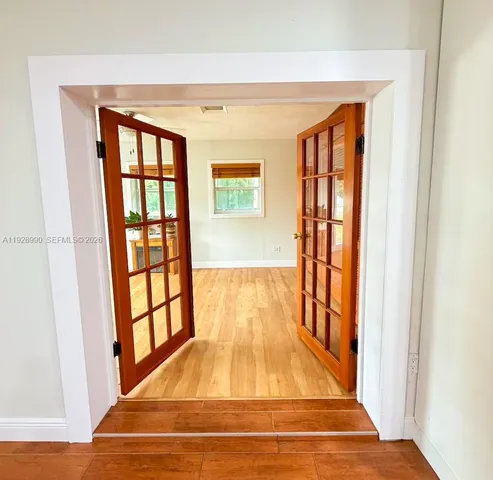 a view of front door with wooden floor and a potted plant