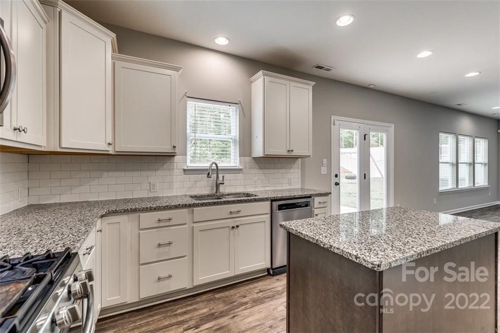 6403 Bluegill Road Charlotte, NC 28216 - Photo 13 of 48 a kitchen with granite countertop cabinets stainless steel appliances a sink and dishwasher with wooden floor