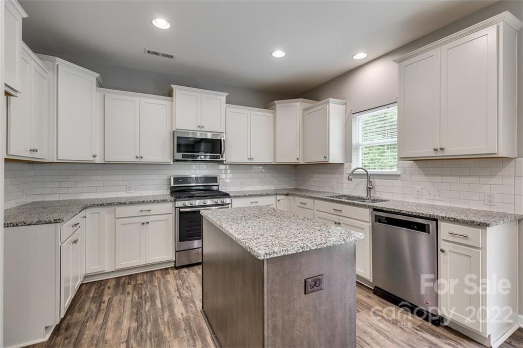 6403 Bluegill Road Charlotte, NC 28216 - Photo 15 of 48 a kitchen with cabinets appliances a sink and a counter top space