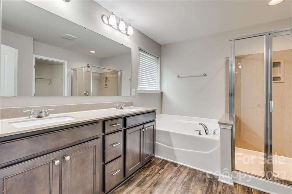 6403 Bluegill Road Charlotte, NC 28216 - Photo 25 of 48 a bathroom with a tub a sink and a large mirror