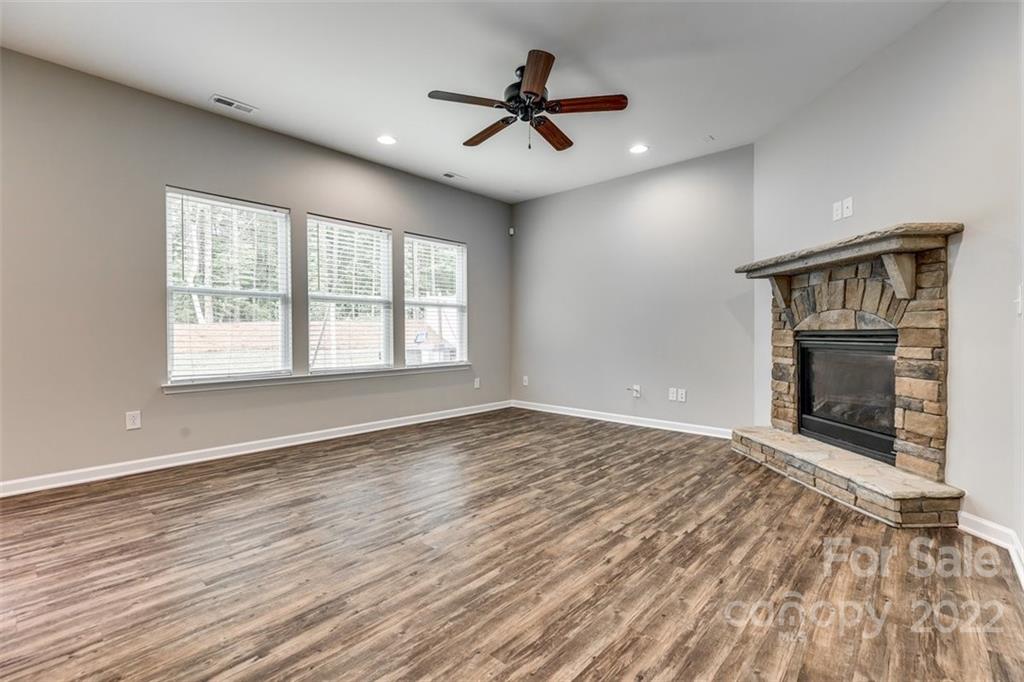 6403 Bluegill Road Charlotte, NC 28216 - Photo 9 of 48 an empty room with wooden floor fireplace and windows