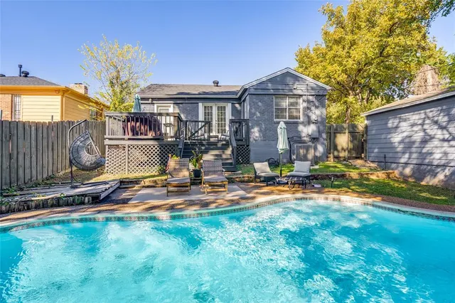 a front view of a house with swimming pool and furniture