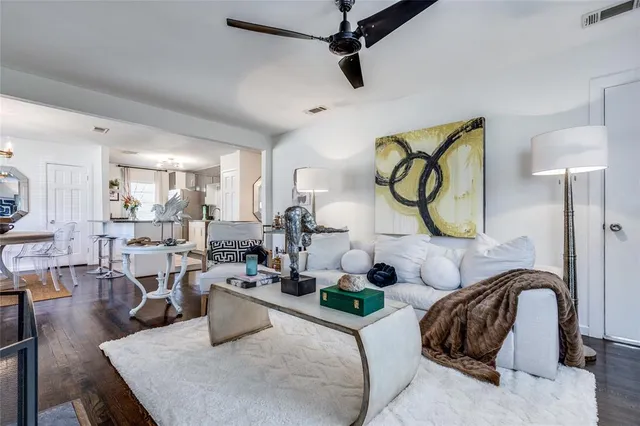 a room with lots of white furniture and chandelier