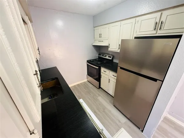 a kitchen with granite countertop white cabinets and white appliances